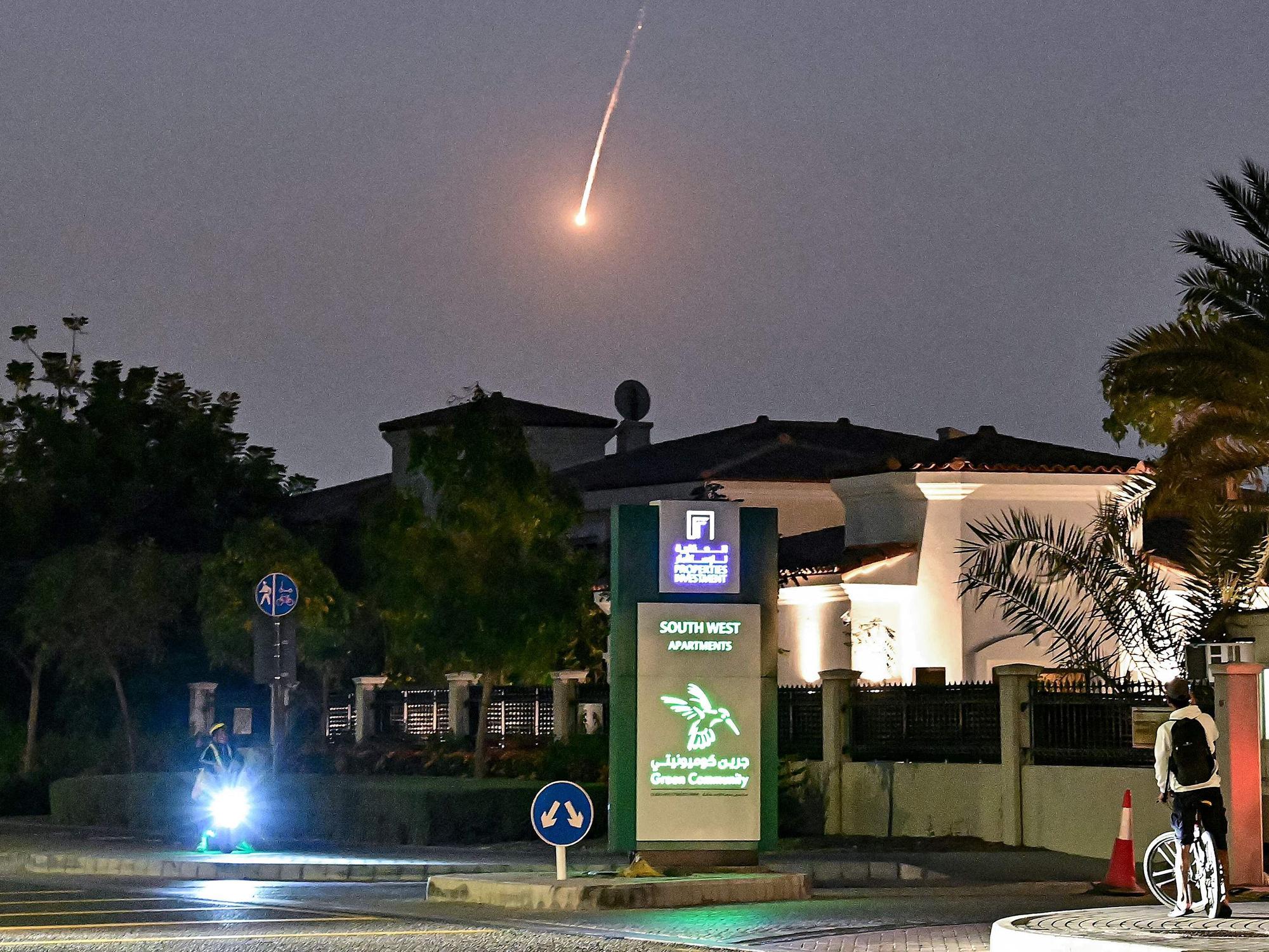 Ein Radfahrer beobachtet, wie am 28. Februar 2026 ein Geschoss über Dubai niedergeht. AFP-Korrespondenten hörten am 28. Februar eine laute Explosion in Dubai, und einer von ihnen sah eine Rauchwolke über der Stadt aufsteigen. Die Explosionen erfolgten im Zuge weitreichender iranischer Angriffe auf den Golf als Vergeltung für US-amerikanische und israelische Angriffe auf den Iran.