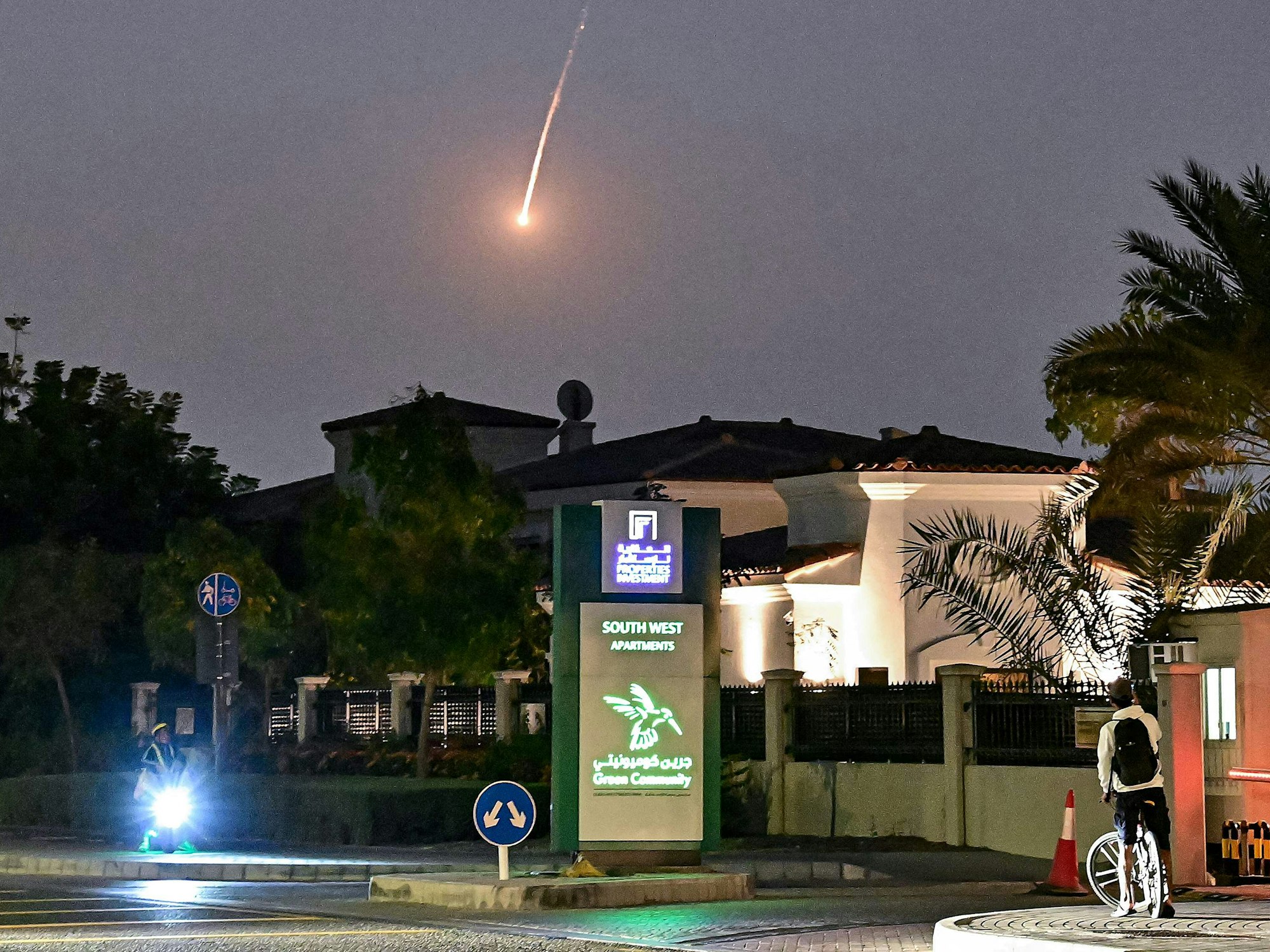Ein Radfahrer beobachtet, wie am 28. Februar 2026 ein Geschoss über Dubai niedergeht. AFP-Korrespondenten hörten am 28. Februar eine laute Explosion in Dubai, und einer von ihnen sah eine Rauchwolke über der Stadt aufsteigen. Die Explosionen erfolgten im Zuge weitreichender iranischer Angriffe auf den Golf als Vergeltung für US-amerikanische und israelische Angriffe auf den Iran.