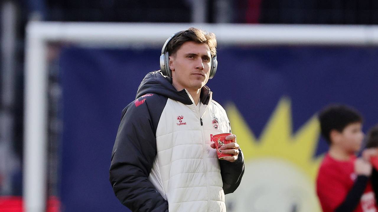 Alessio Castro-Montes (1. FC Köln) steht mit Kopfhörern auf dem Platz.