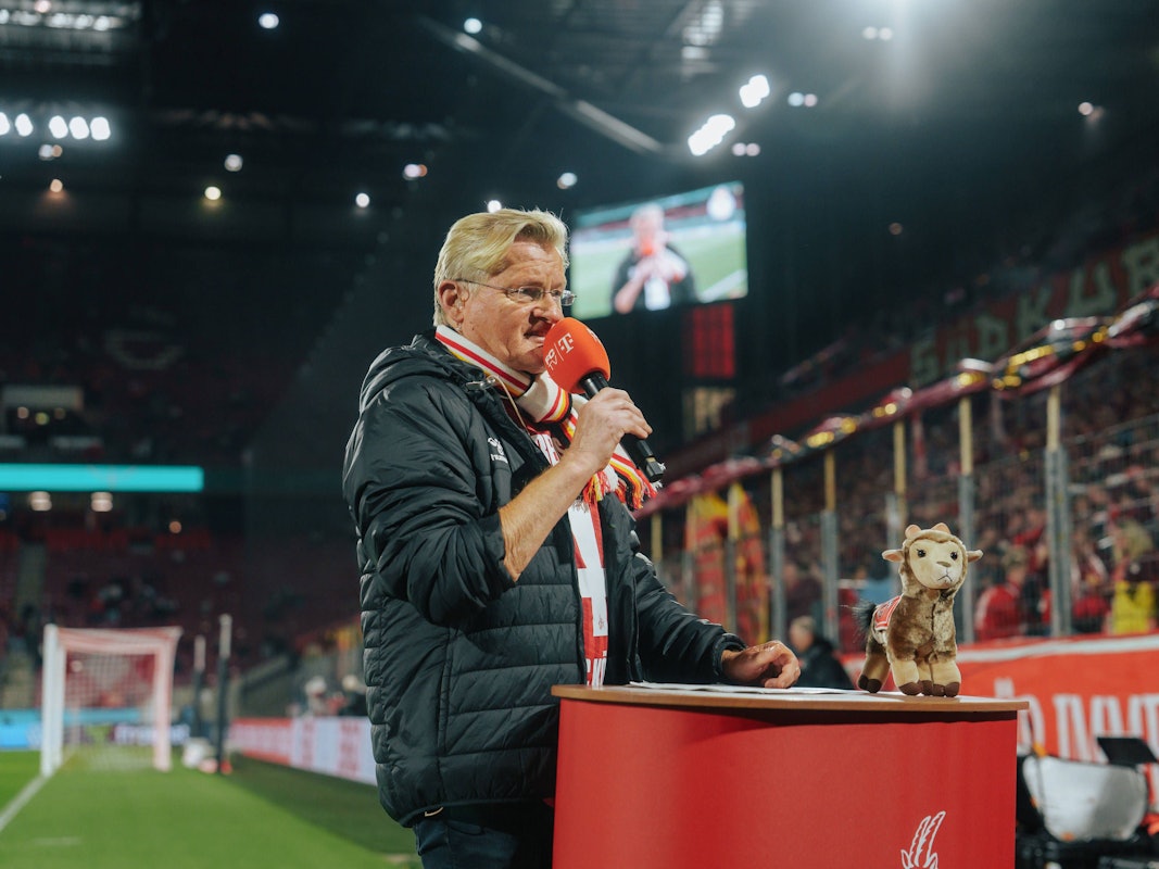Michael Trippel spricht im Stadion in ein Mikro.