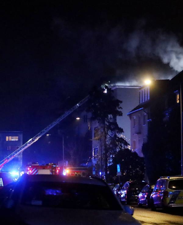 Die Feuerwehr ist an einem mehrstöckigen Gebäude im Einsatz, die Drehleiter ist ausgefahren.