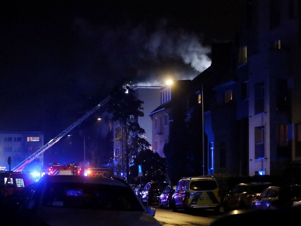 Die Feuerwehr ist an einem mehrstöckigen Gebäude im Einsatz, die Drehleiter ist ausgefahren.
