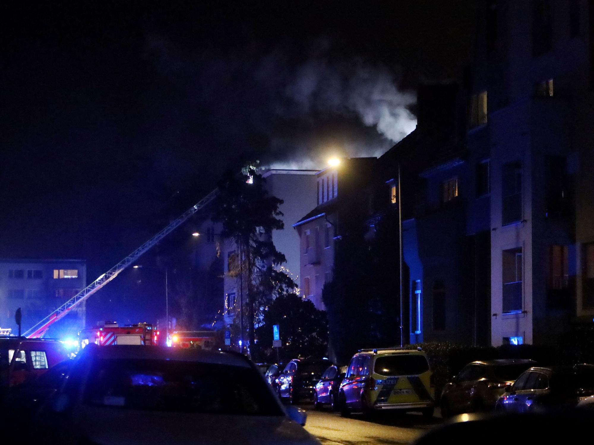 Die Feuerwehr ist an einem mehrstöckigen Gebäude im Einsatz, die Drehleiter ist ausgefahren.