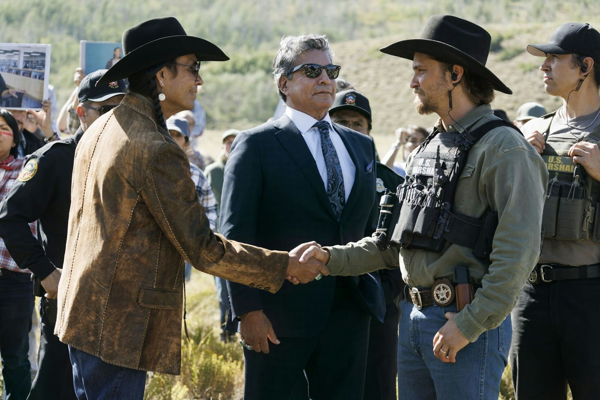 Kayce Dutton (Luke Grimes, rechts) trifft bei einer Veranstaltung Mo (Mo Brings Plenty, links) und Thomas Rainwater (Gil Birmingham) wieder. (Bild: © Paramount+)
