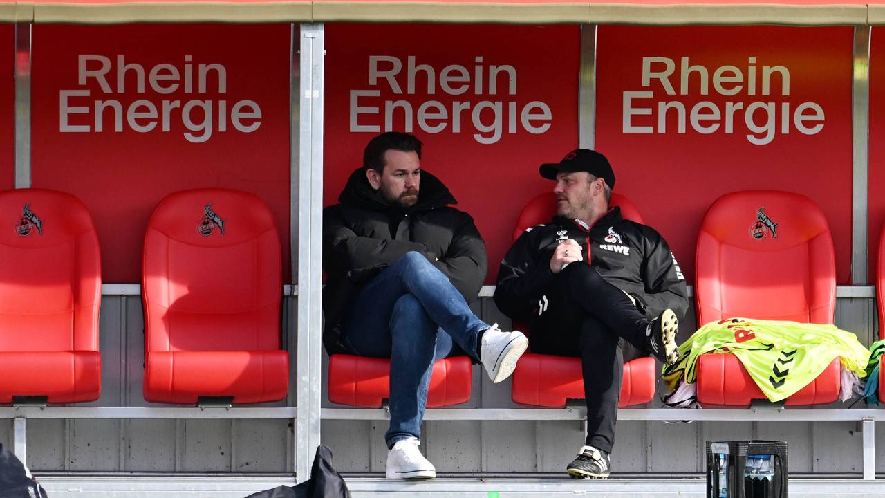 Kölns Sportchef Thomas Kessler und FC-Trainer Lukas Kwasniok sitzen im Franz-Kremer-Stadion auf der Trainerbank und reden.