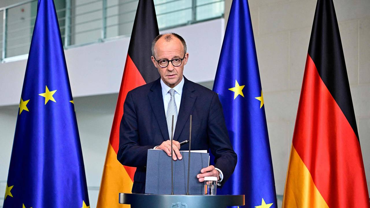 Bundeskanzler Friedrich Merz steht an einem Rednerpult, hinter sich jeweils zwei Deutschland- sowie EU-Fahnen.
