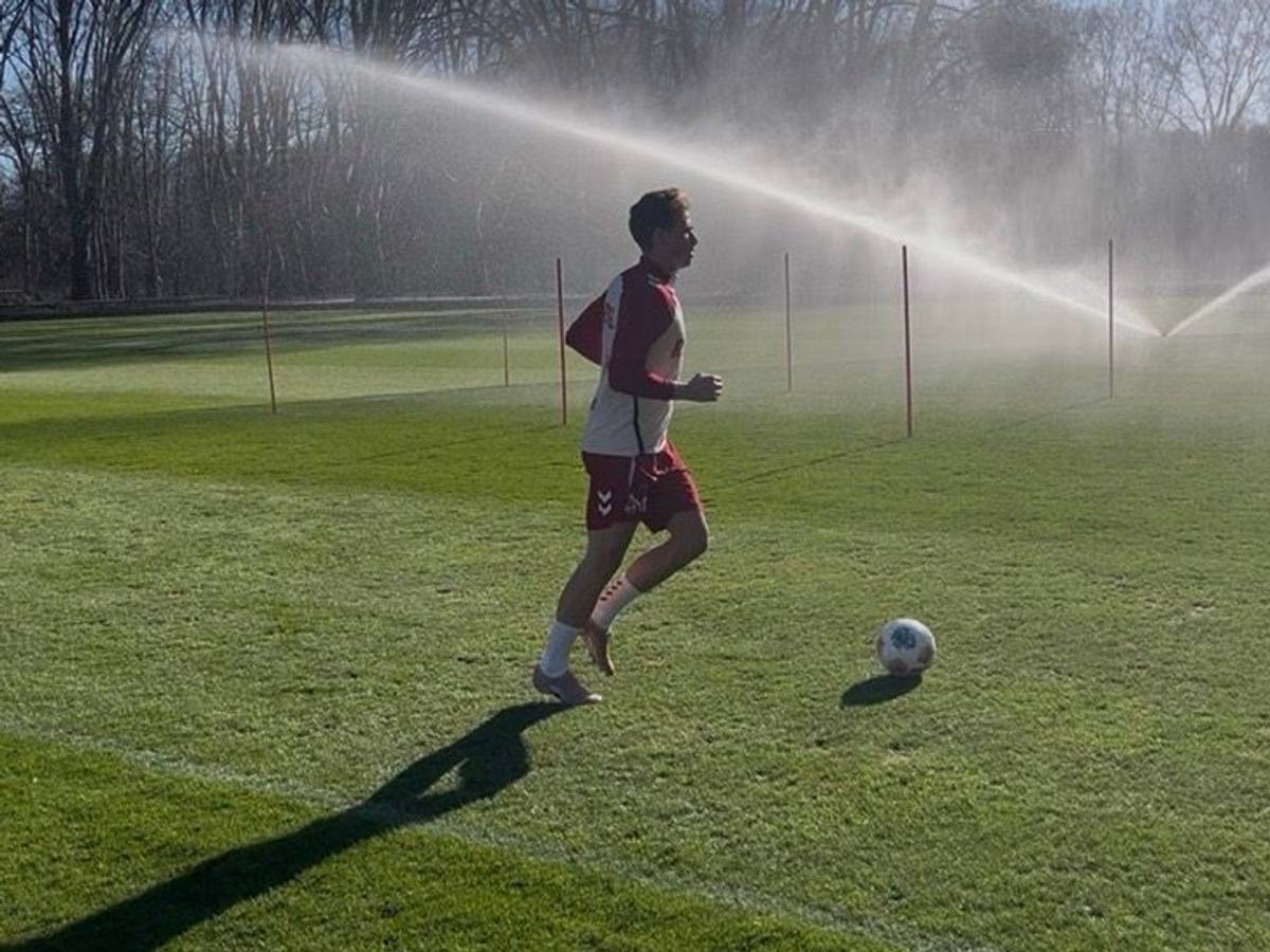 Sebastian Sebulonsen läuft über den Rasen. Vor ihm ein Ball, im Hintergrund läuft ein Rasensprenger.