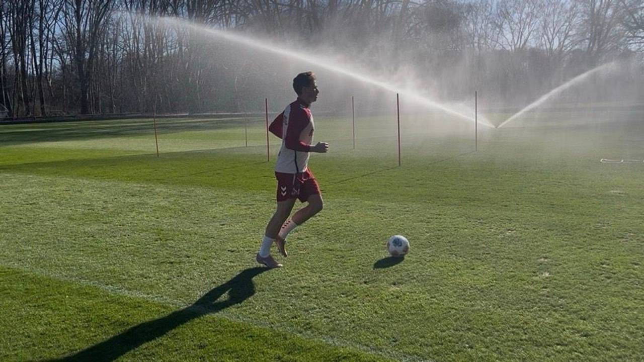 Sebastian Sebulonsen läuft über den Rasen. Vor ihm ein Ball, im Hintergrund läuft ein Rasensprenger.