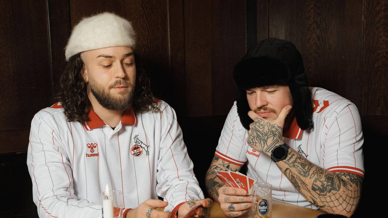 Zwei Models zeigen das neue Sondertrikot des 1. FC Köln in der Kneipe.