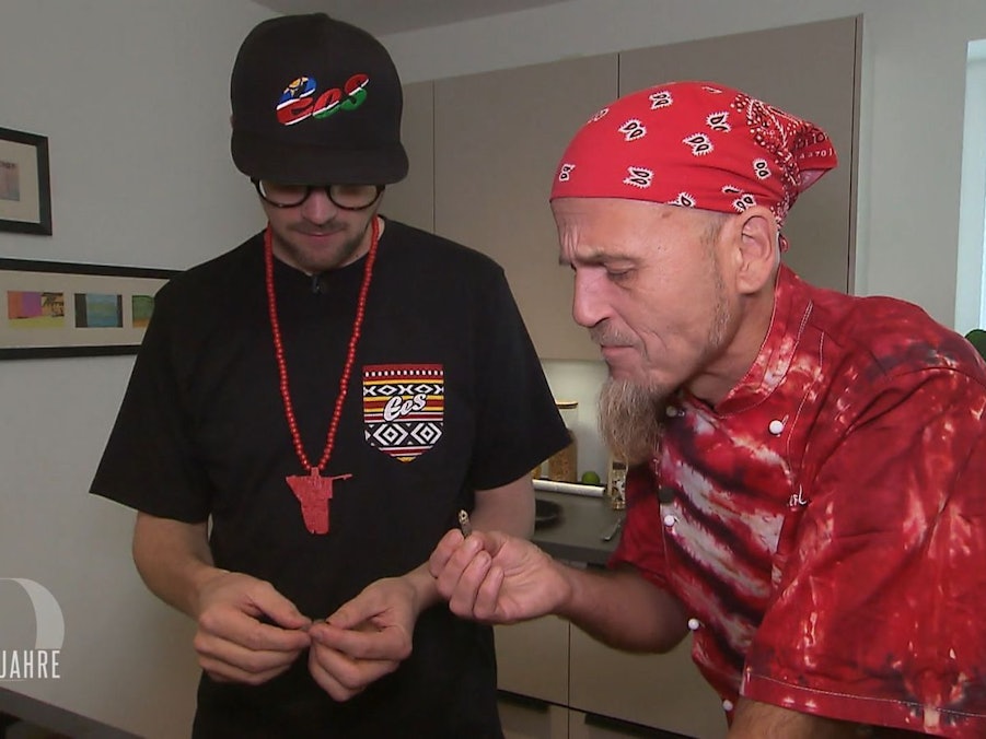 Ralf Zacherl (rechts) taucht überraschend als Schnibbelhilfe bei Ees auf und probiert zum ersten Mal einen Mopanewurm.
(Bild: RTL)