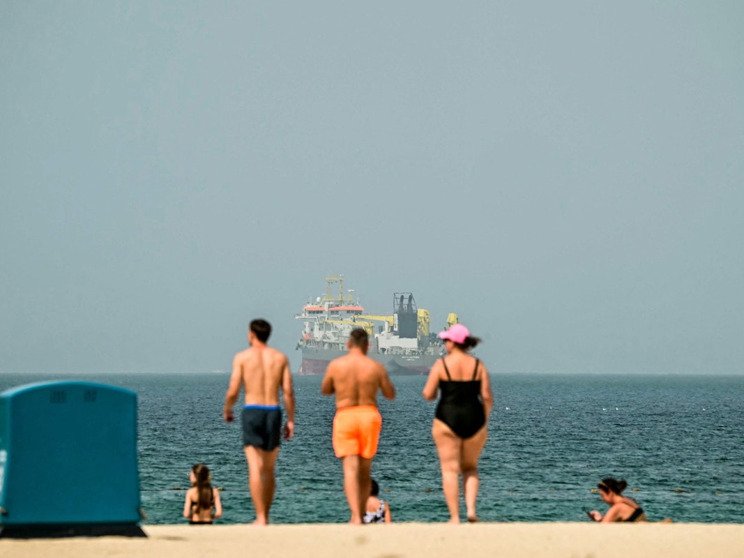 Urlauber und Urlauberinnen genießen die Sonne am Strand in Dubai. Der AFP-Fotograf machte das Foto am 2. März 2026.