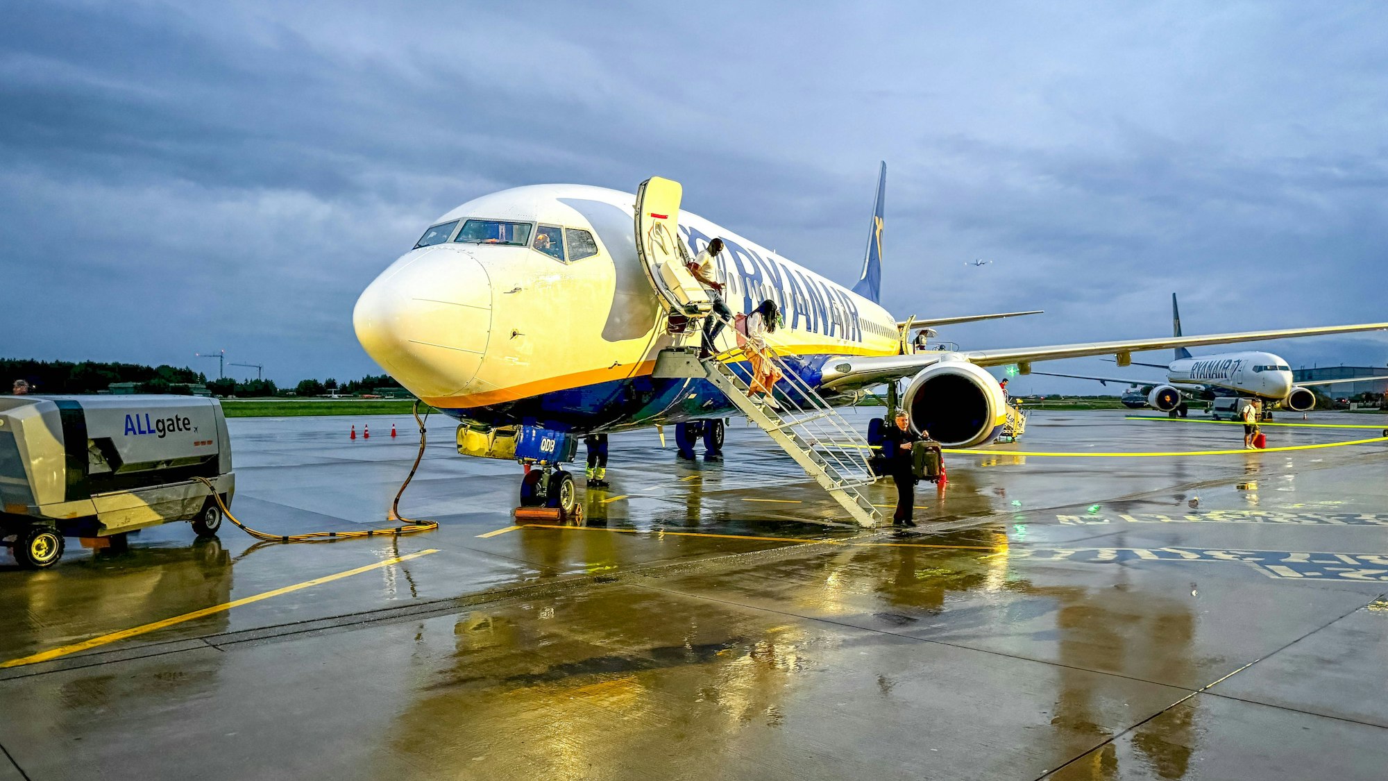 Flugzeug auf nassem Rollfeld, Passagiere steigen aus