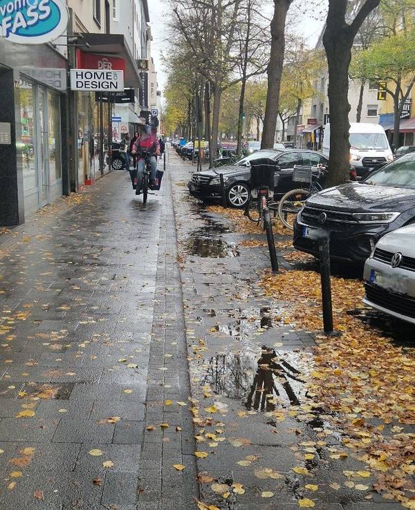 Ein Lieferdienstfahrer fährt auf dem Gehweg.