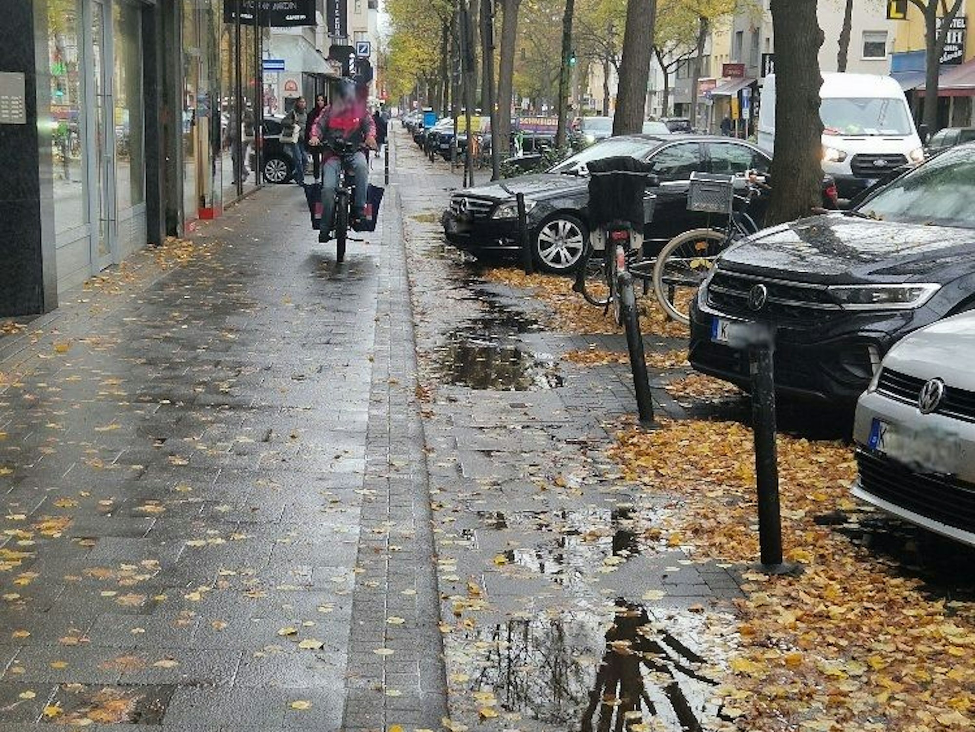 Ein Essenslieferant auf einem Fahrrad ist auf einem Gehweg unterwegs.