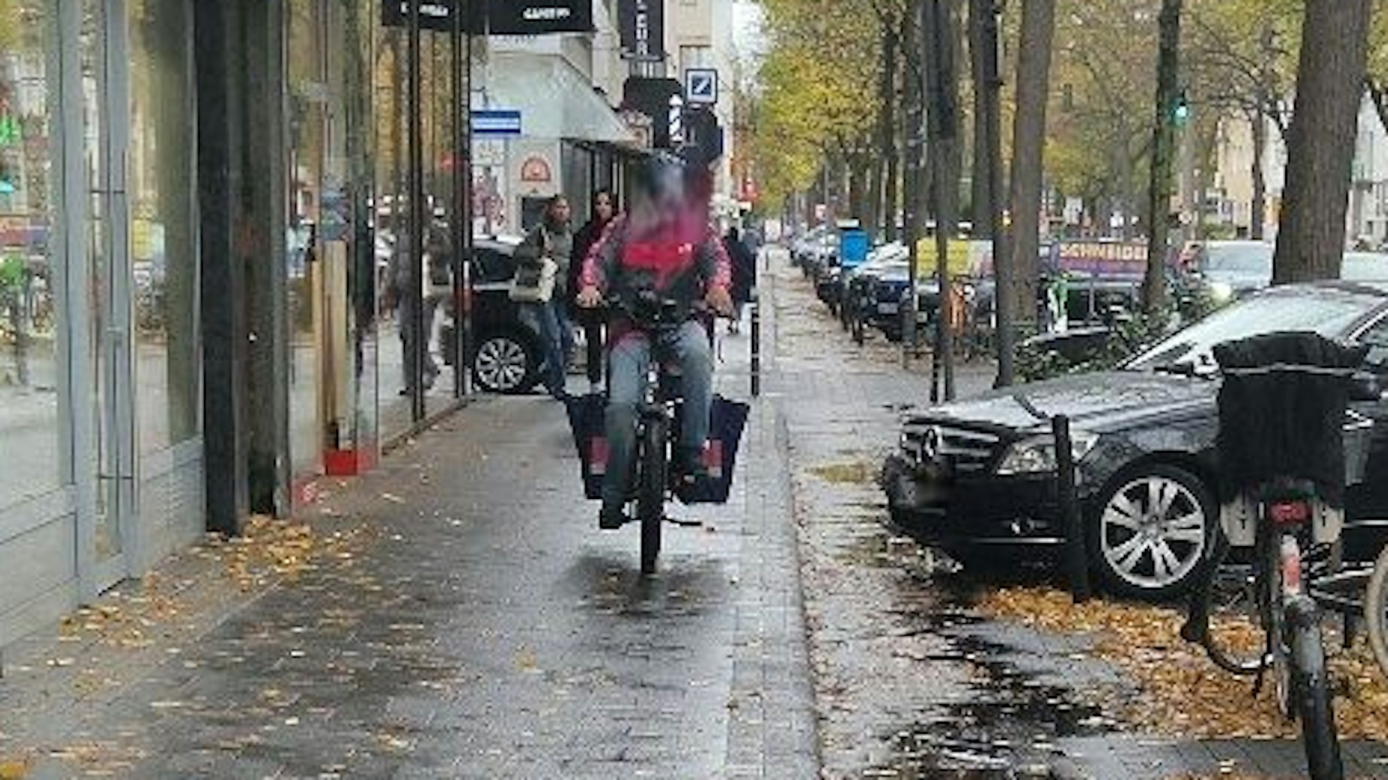 Ein Lieferdienstfahrer fährt auf dem Gehweg.