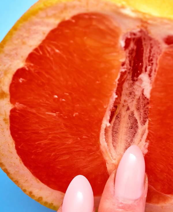 Bild von einer Blutorange mit Fingern.