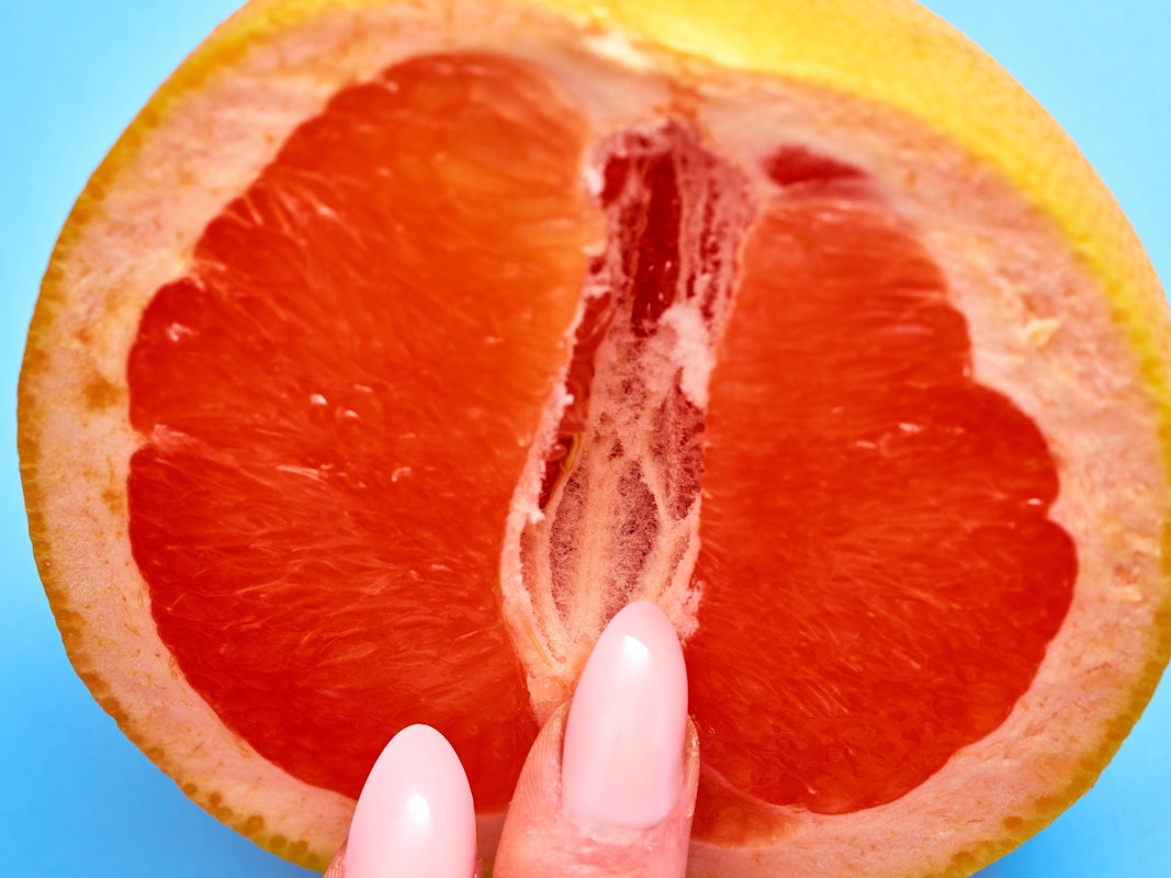 Bild von einer Blutorange mit Fingern.