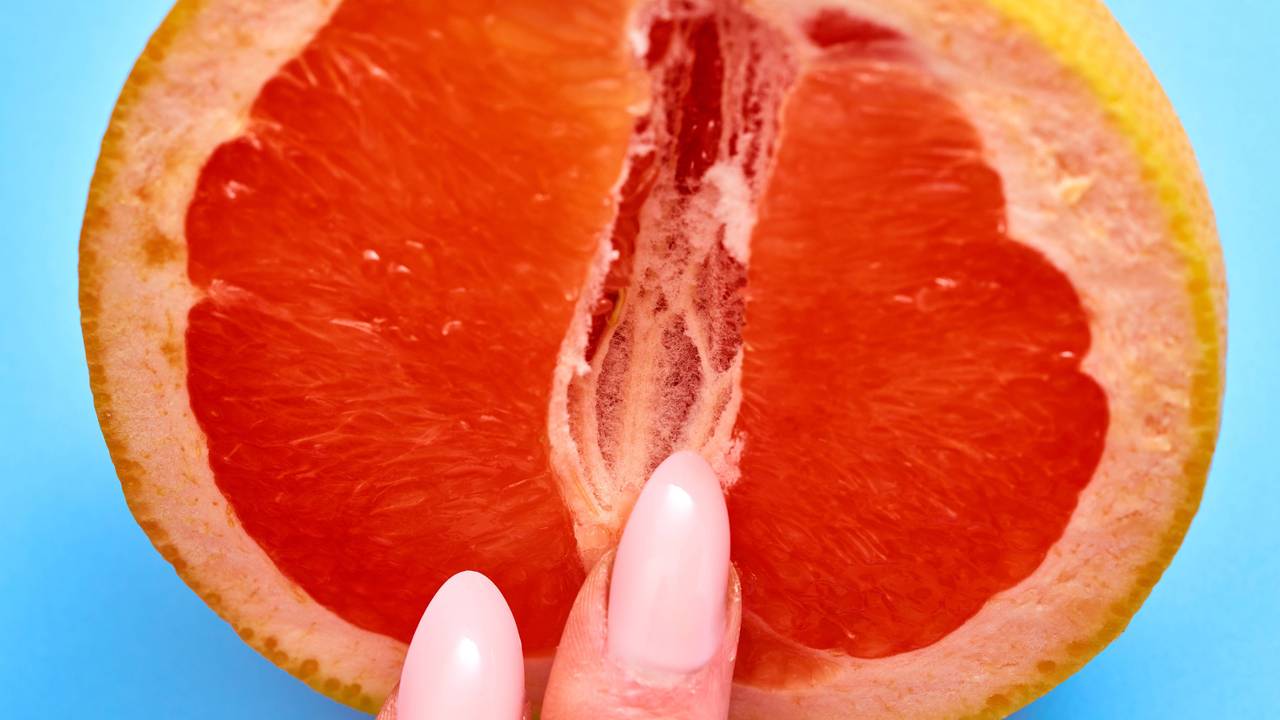 Bild von einer Blutorange mit Fingern.