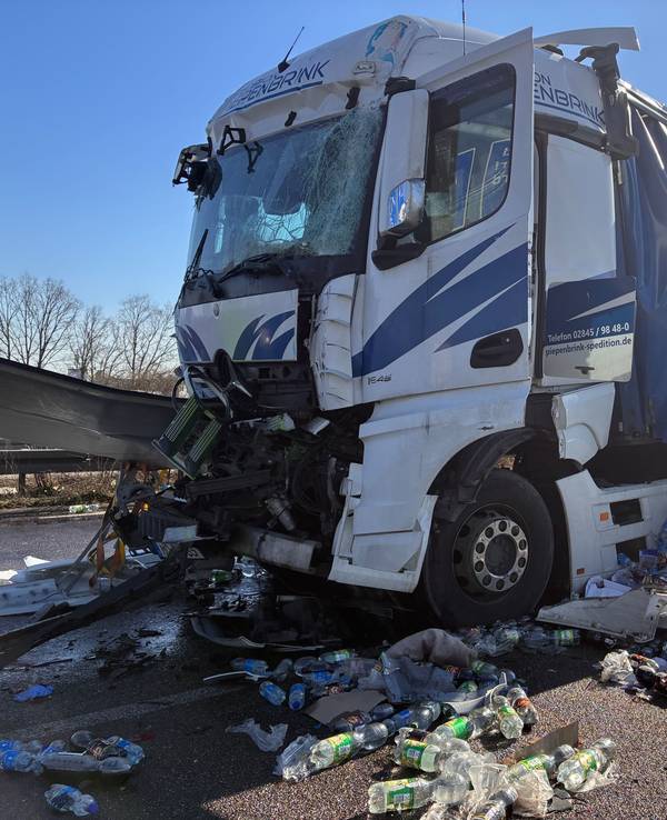 Ein beschädigter Lkw steht auf der Fahrbahn, er hat seine Ladung verloren. PET-Flaschen liegen um ihn herum.