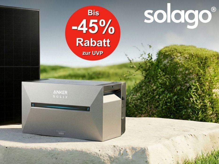 Vor einer grünen Grasfläche auf einer Steinplatte steht ein Balkonkraftwerk bestehend aus Solarpanelen und einem Anker Solix 3 Pro Speicher.