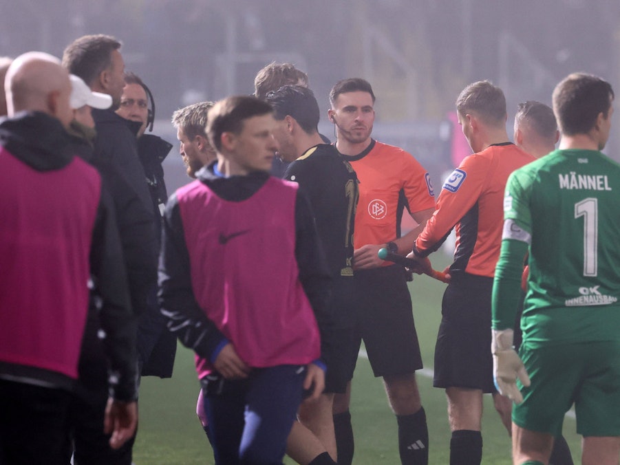 Schiedsrichter Tom Bauer rief die Spieler von 1860 München und Erzgebirge Aue wegen dichten Nebels zusammen.