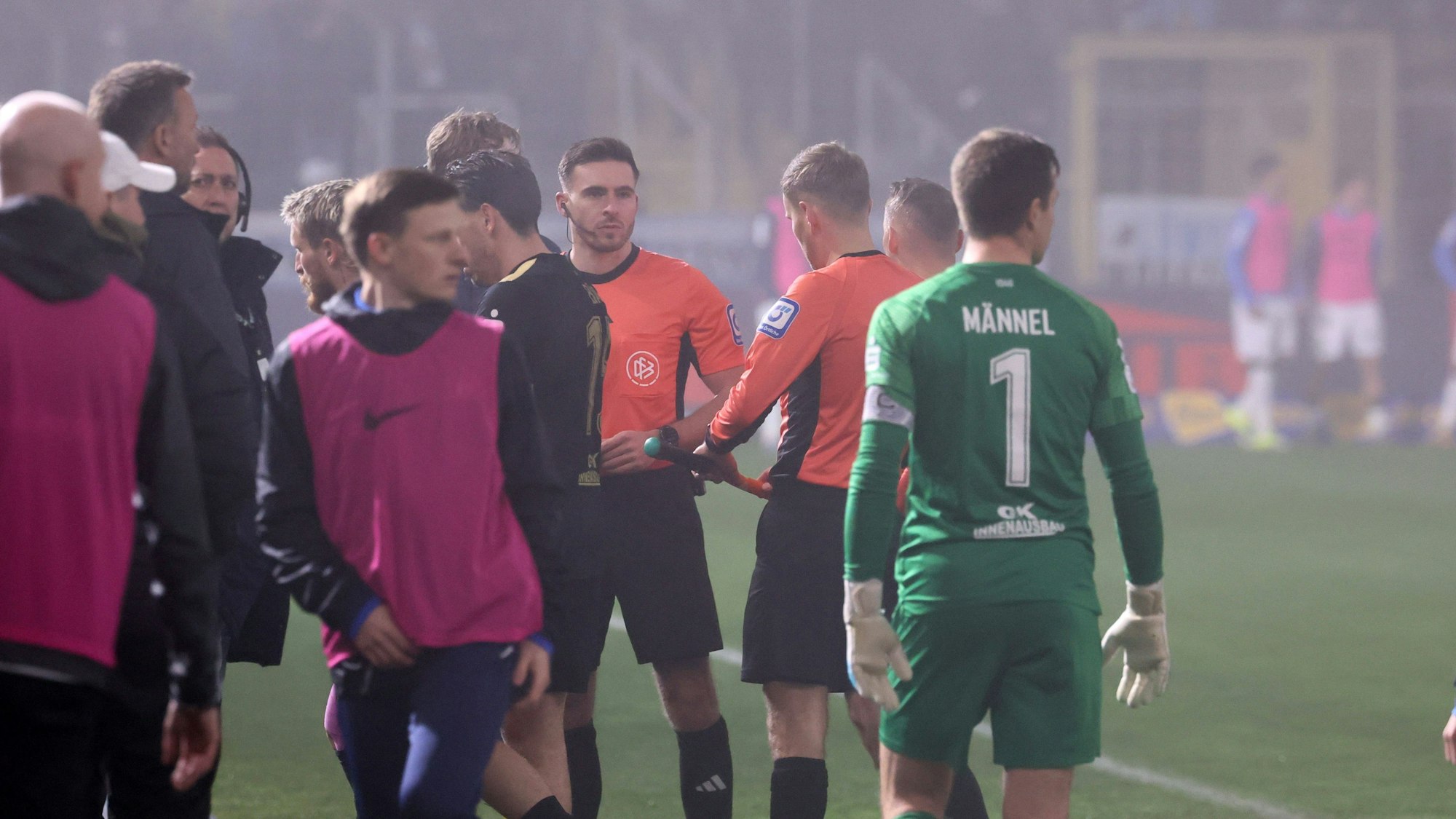 Schiedsrichter Tom Bauer rief die Spieler von 1860 München und Erzgebirge Aue wegen dichten Nebels zusammen.