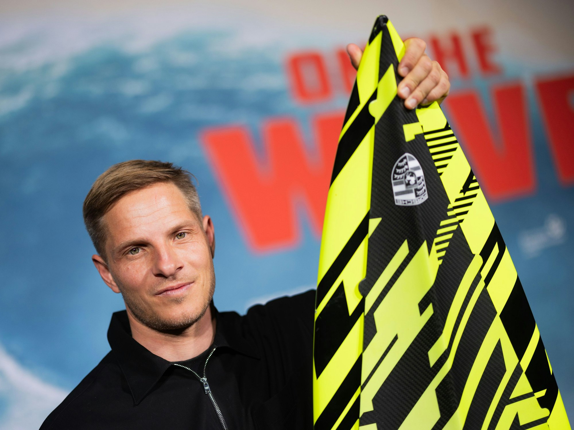 Sebastian Steudtner zeigt sein Surfbrett.