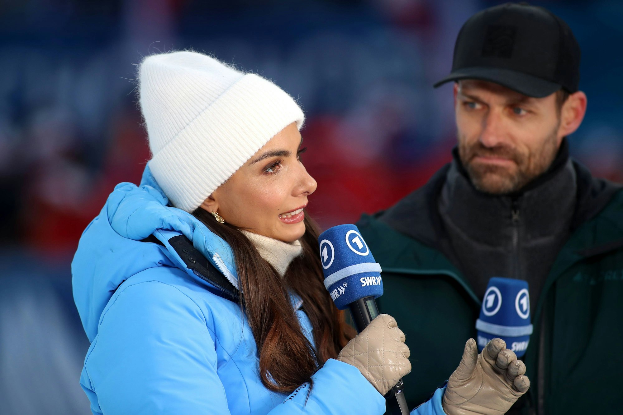 Lea Wagner spricht in ein ARD-Mikro, im Hintergrund steht Sven Hannawald.