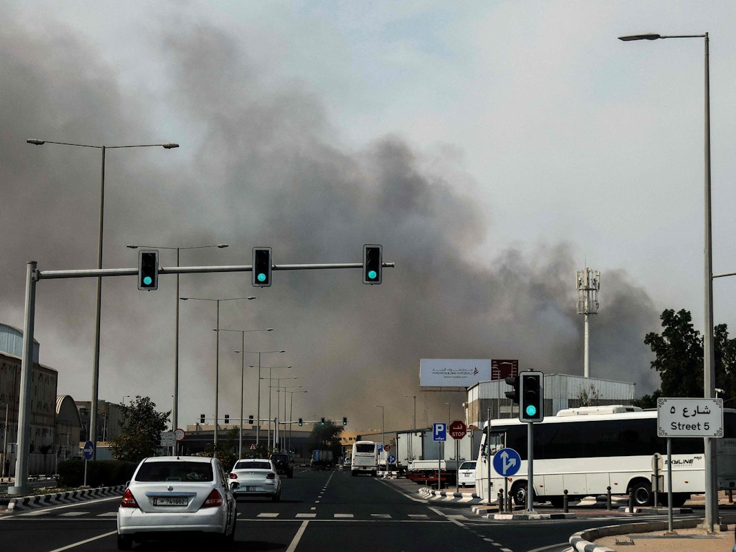 Autofahrer fahren am 1. März an einer Rauchwolke vorbei, die nach einem iranischen Angriff im Industriegebiet von Doha aufsteigt.