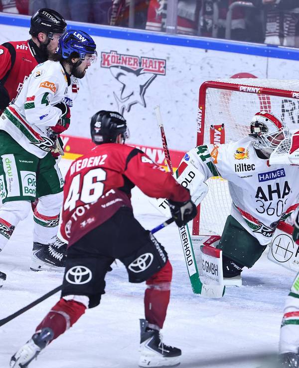 Kevin Niedenz (2.v.l.) schießt den Puck ins Tor.