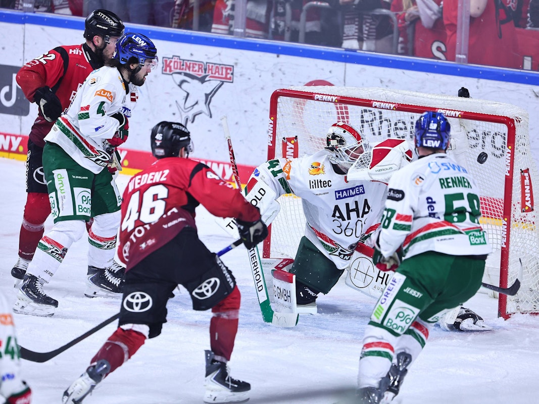 Kevin Niedenz (2.v.l.) schießt den Puck ins Tor.