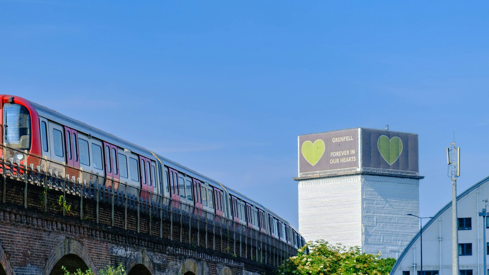 Zug und Grenfell Tower unter blauem Himmel