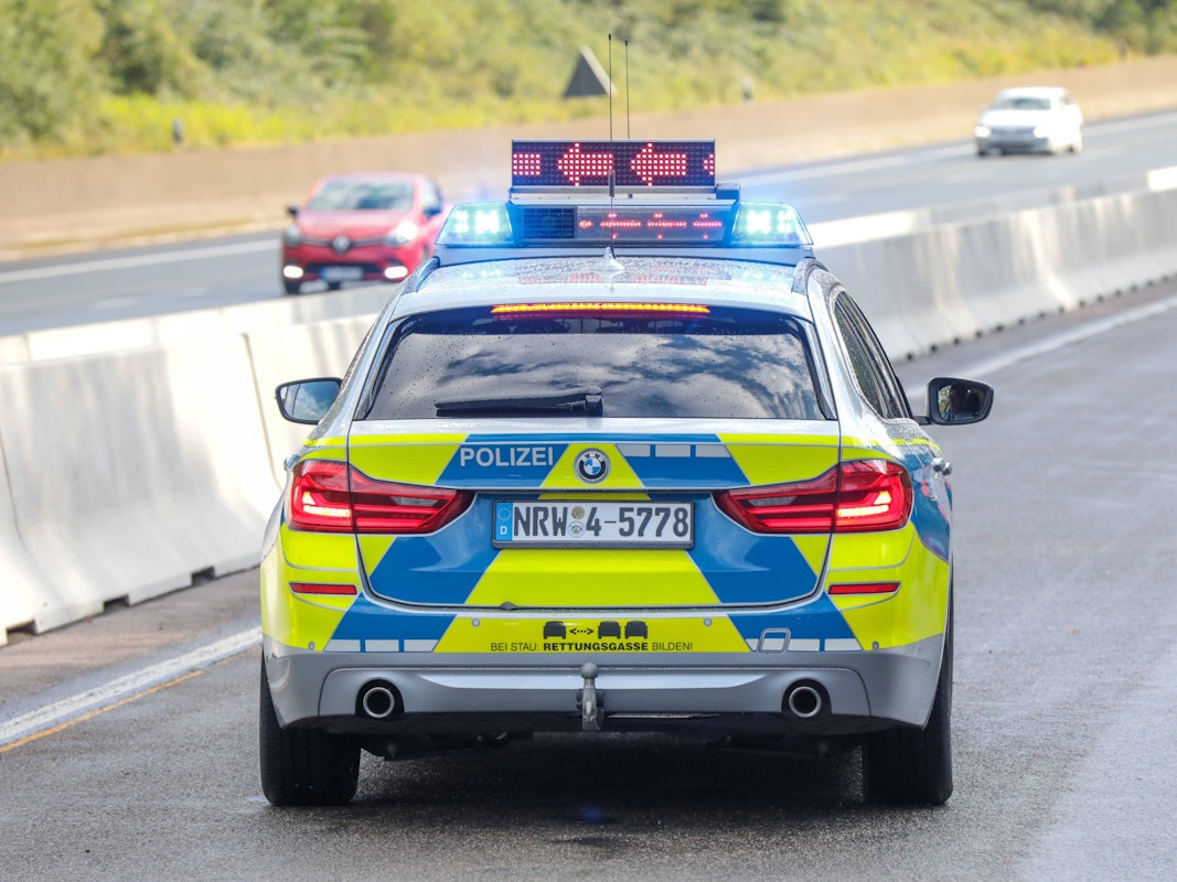 Ein Polizeifahrzeug steht auf der Fahrbahn.