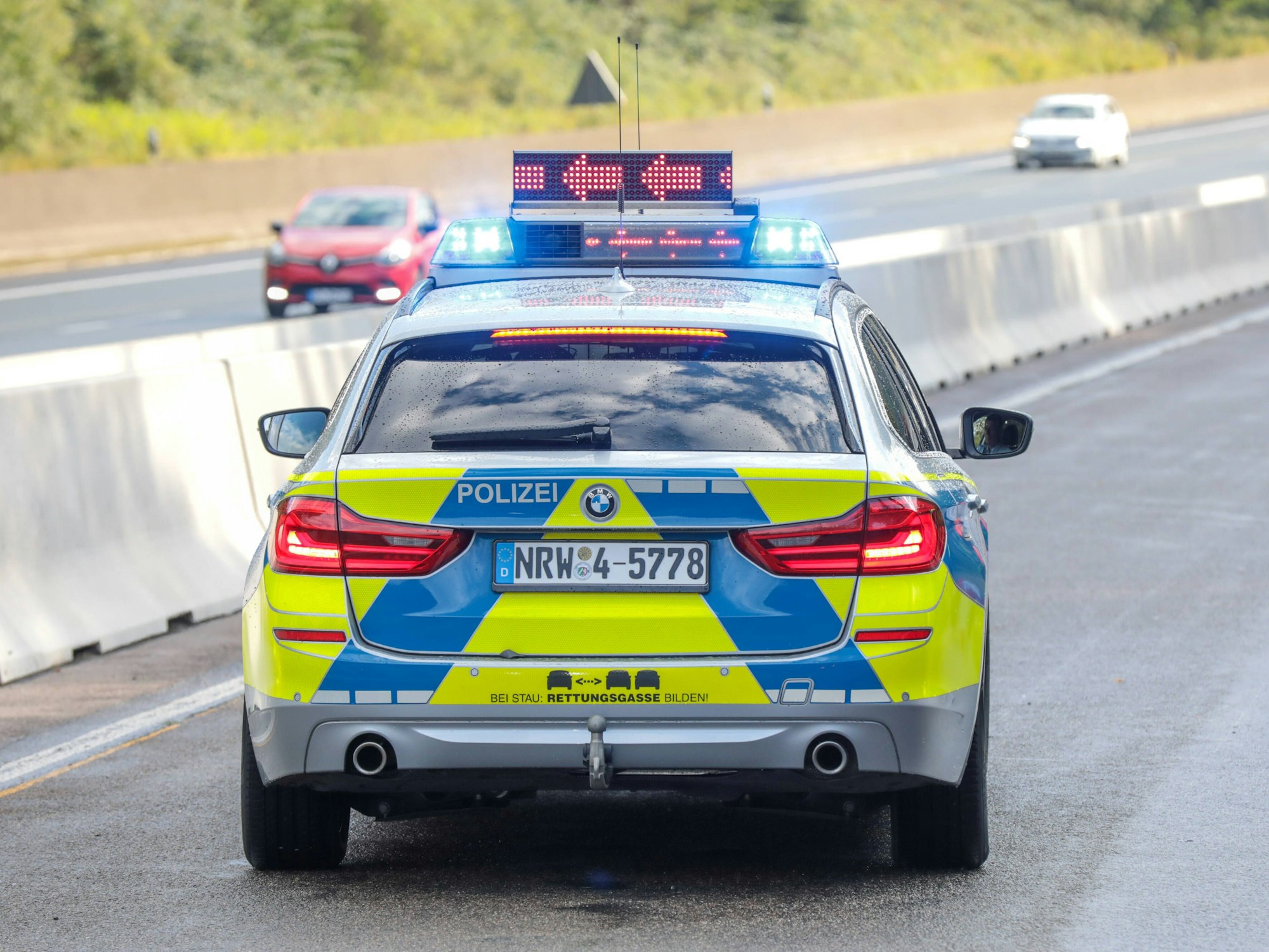 Ein Polizeifahrzeug steht auf der Fahrbahn.