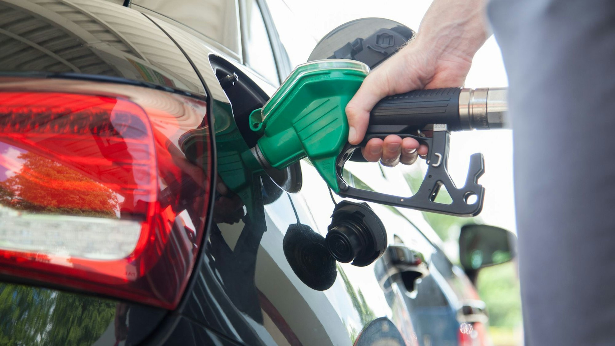 Mann betankt sein Auto