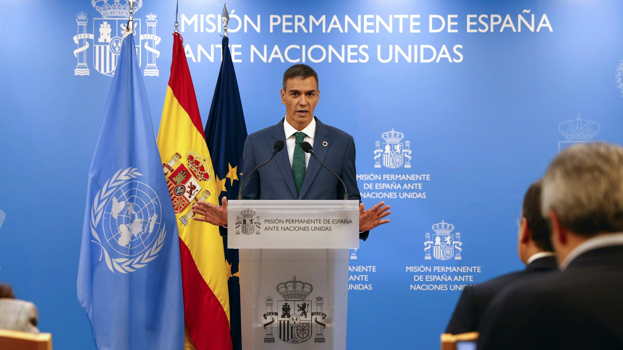 Pedro Sánchez spricht vor Fahnen und Text