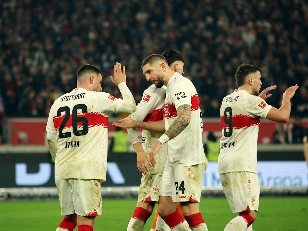 Deniz Undav (l.) und Julian Chabot (2.v.l.) klatschen sich bei einem Spiel des VfB Stuttgart ab.