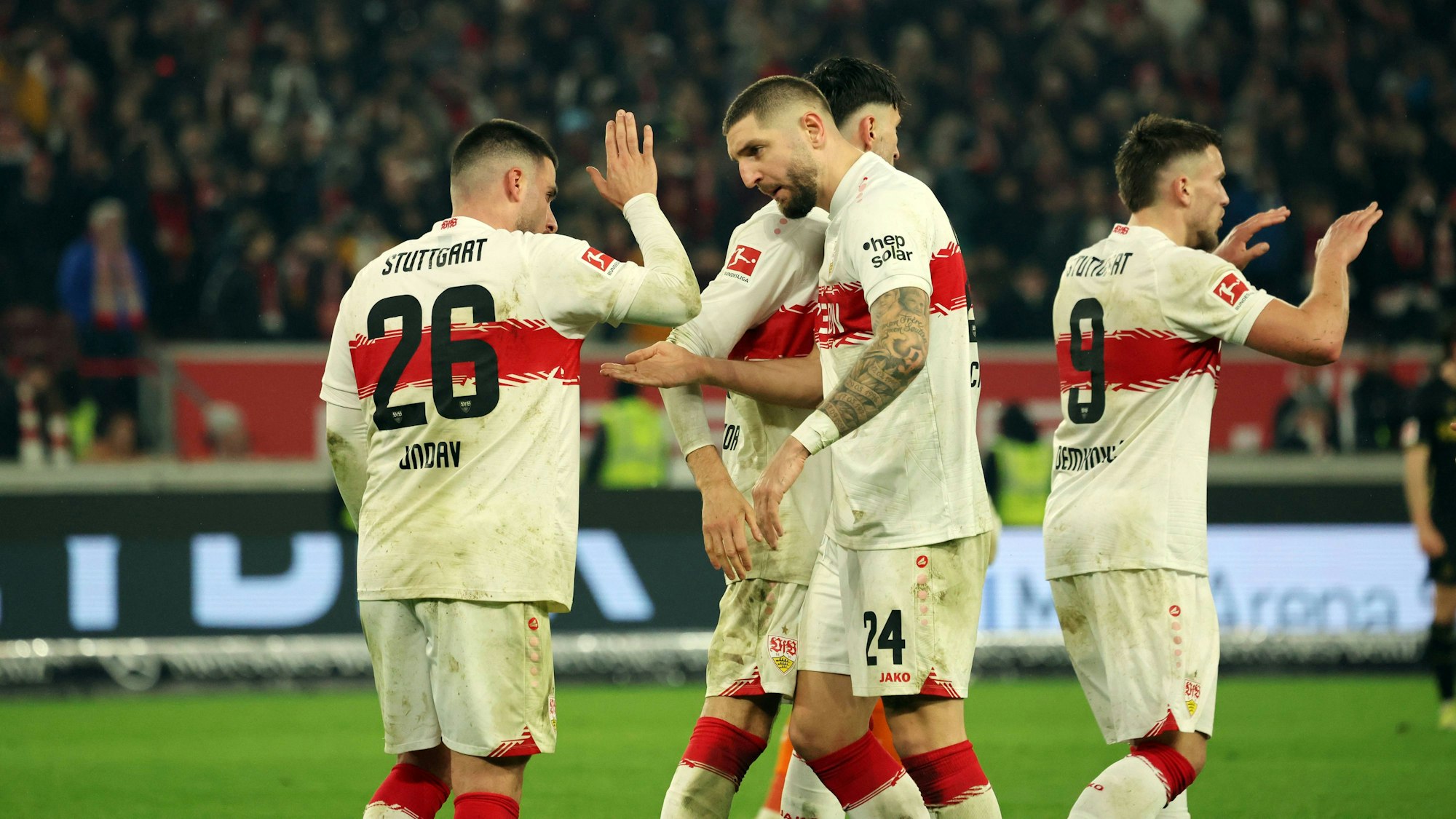 Deniz Undav (l.) und Julian Chabot (2.v.l.) klatschen sich bei einem Spiel des VfB Stuttgart ab.