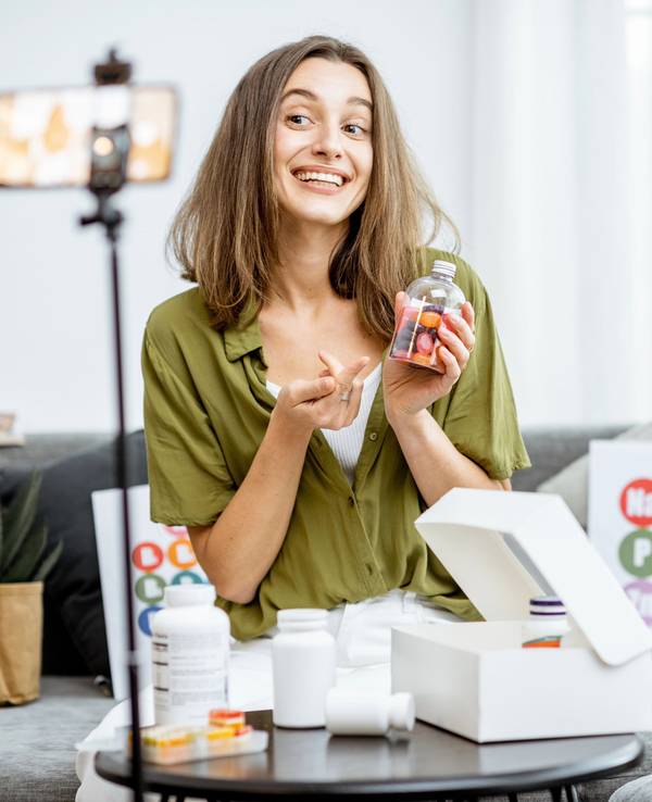 Eine Influencerin hält Pillen in die Kamera