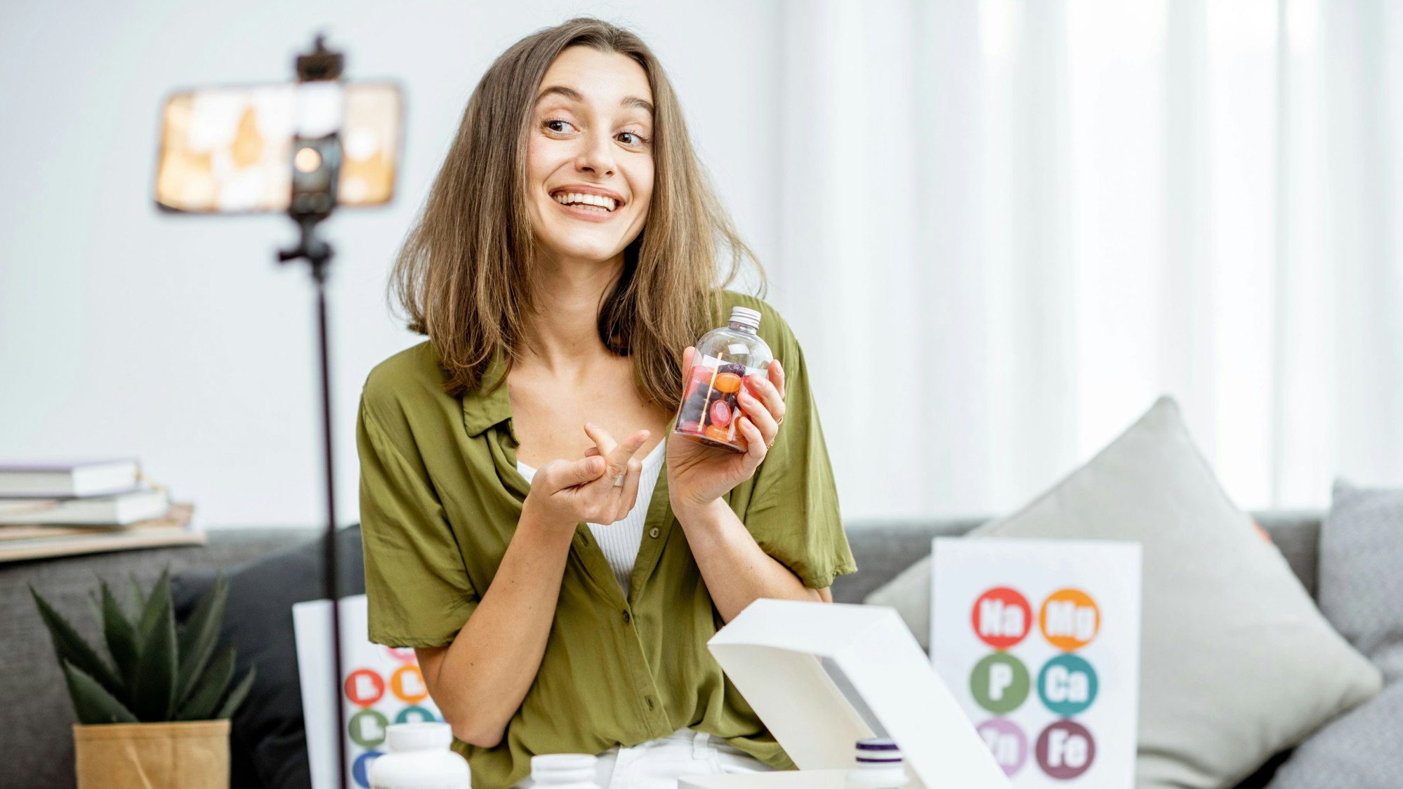Eine Influencerin hält Pillen in die Kamera