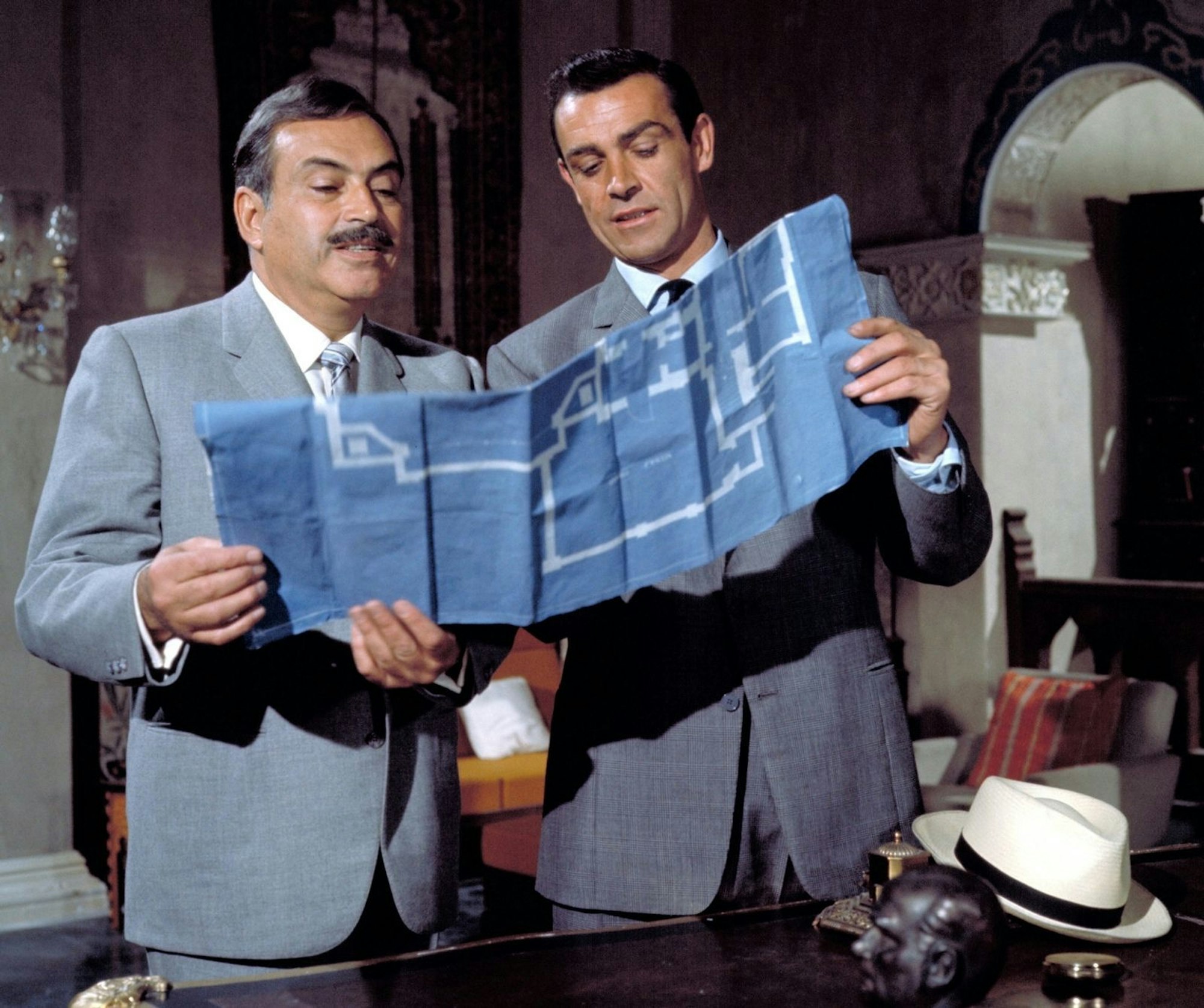 Der türkische Kontaktmann Kerim Bey (Pedro Armendáriz, links) hat James Bond (Sean Connery) unterirdische Pläne des russischen Konsulats besorgt. (Bild: RTL / (c) 1963 Danjaq, LLC and Metro-Goldwyn-Mayer Studios Inc. All Rights Reserved)