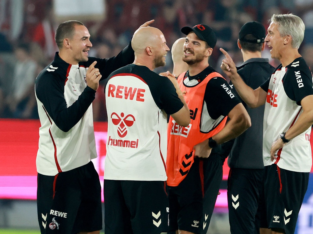 Das Trainerteam des 1. FC Köln spricht nach einem Spiel im Kreis miteinander.
