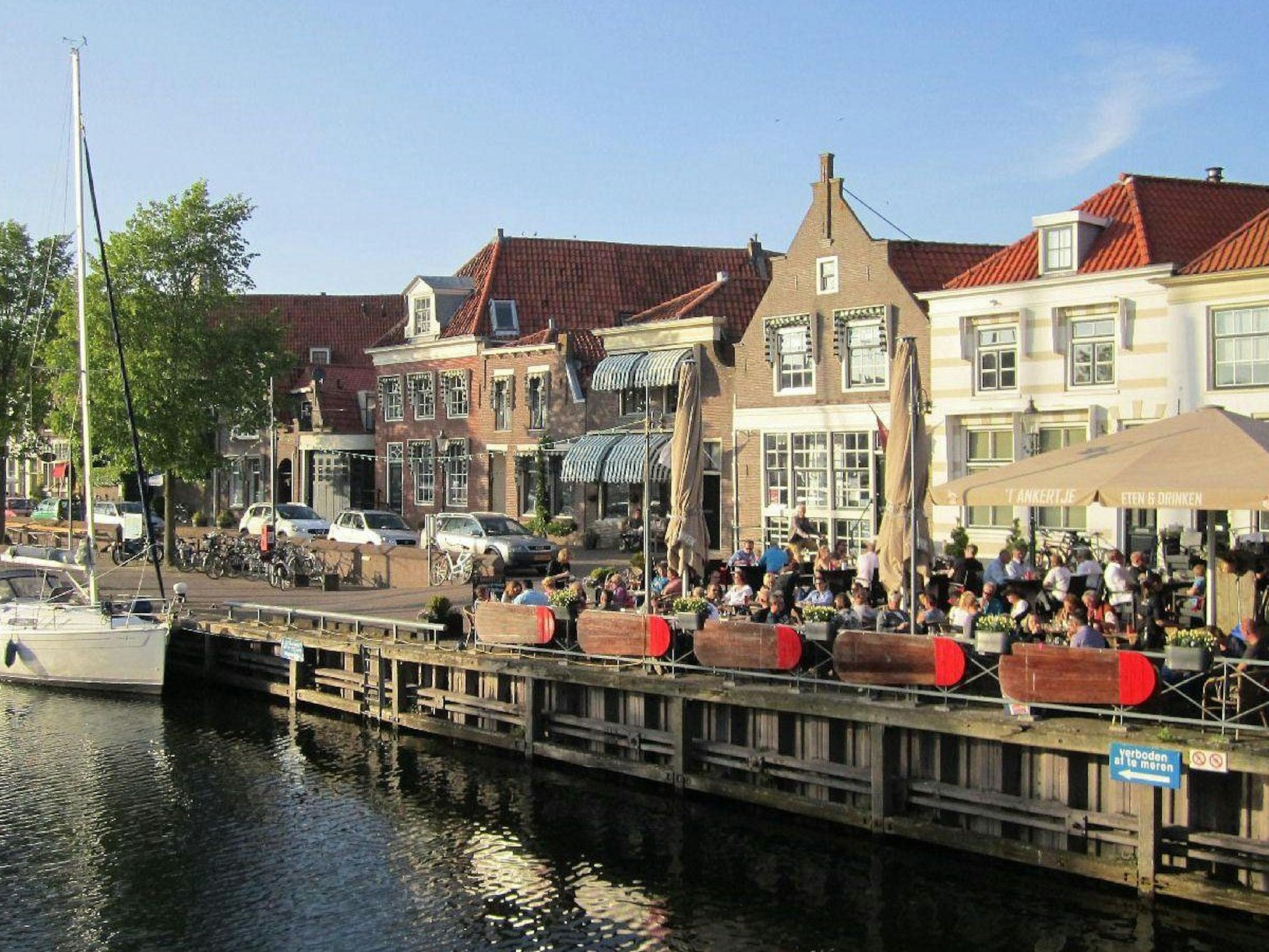 Ein Lokal direkt an einer Gracht, auf der Schiffe ankern