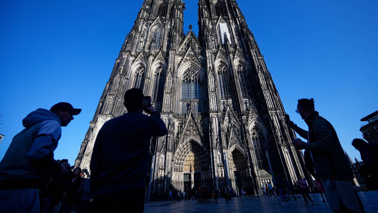 Touristen fotografieren den Kölner Dom.
