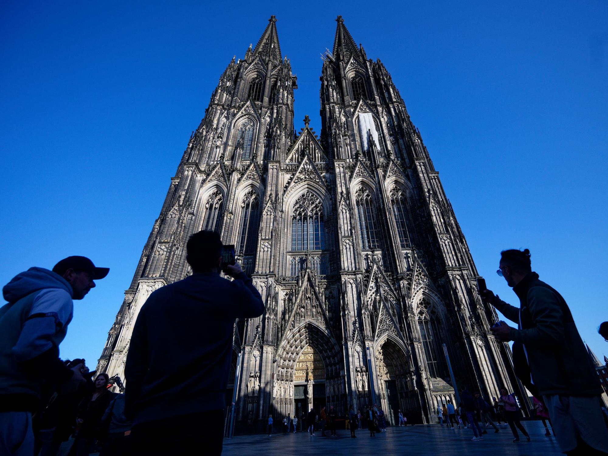 Touristen fotografieren den Kölner Dom.