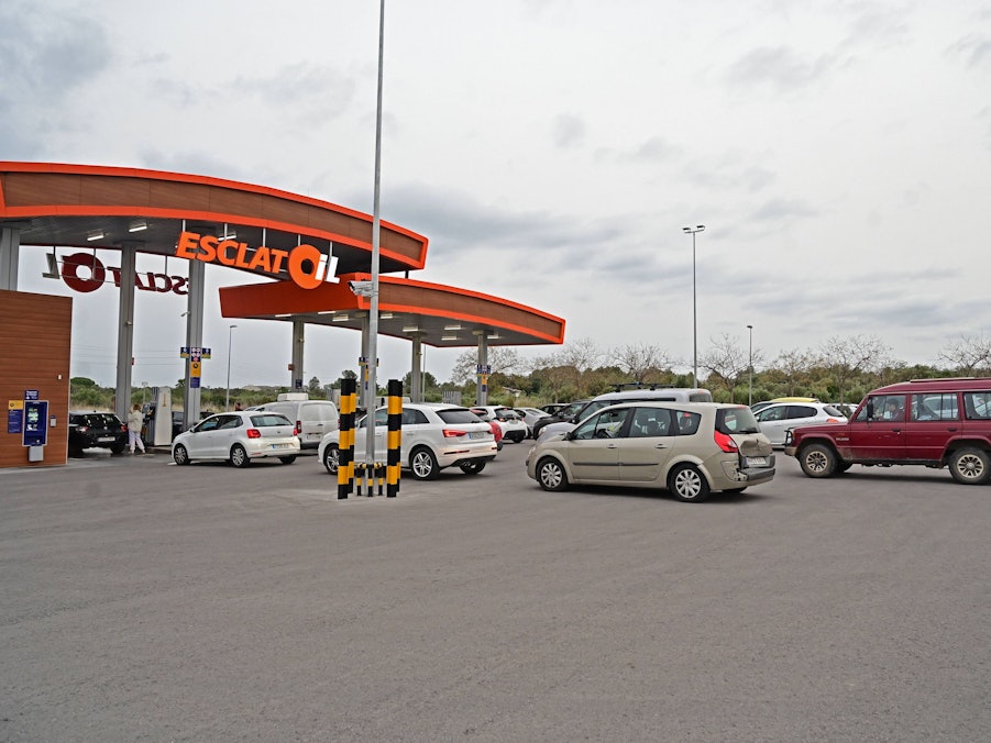 Tankstelle mit Fahrzeugen und Personen