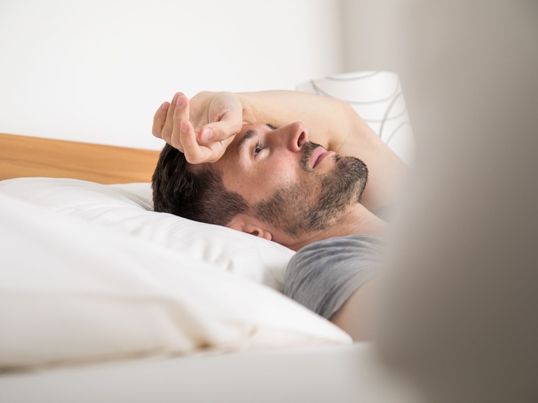 Ein junger Mann liegt im Bett