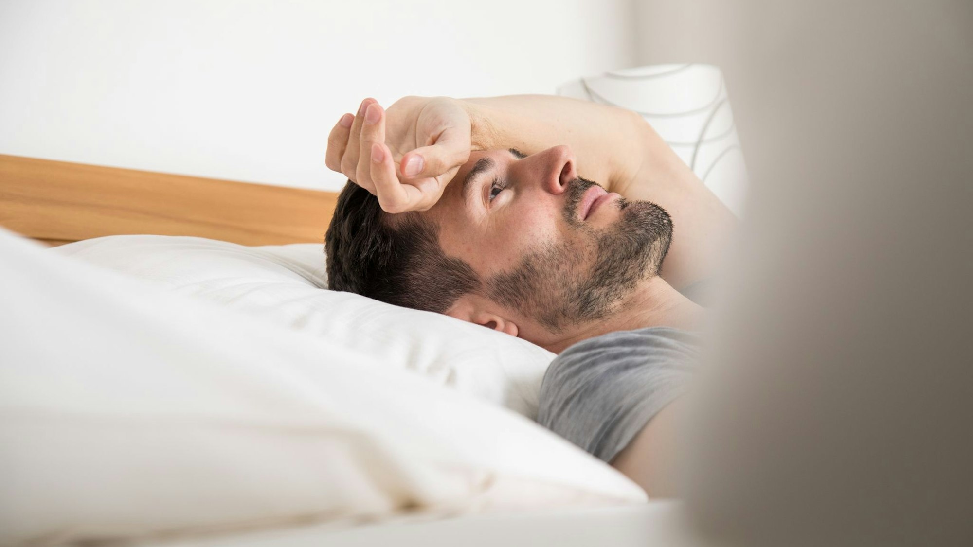 Ein junger Mann liegt im Bett