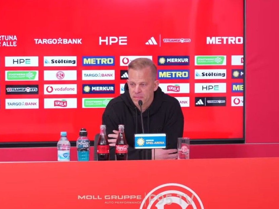 Markus Anfang sitzt auf einer Pressekonferenz mit Tränen in den Augen.