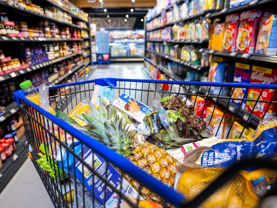 Ein gefüllter Einkaufswagen steht im Supermarkt